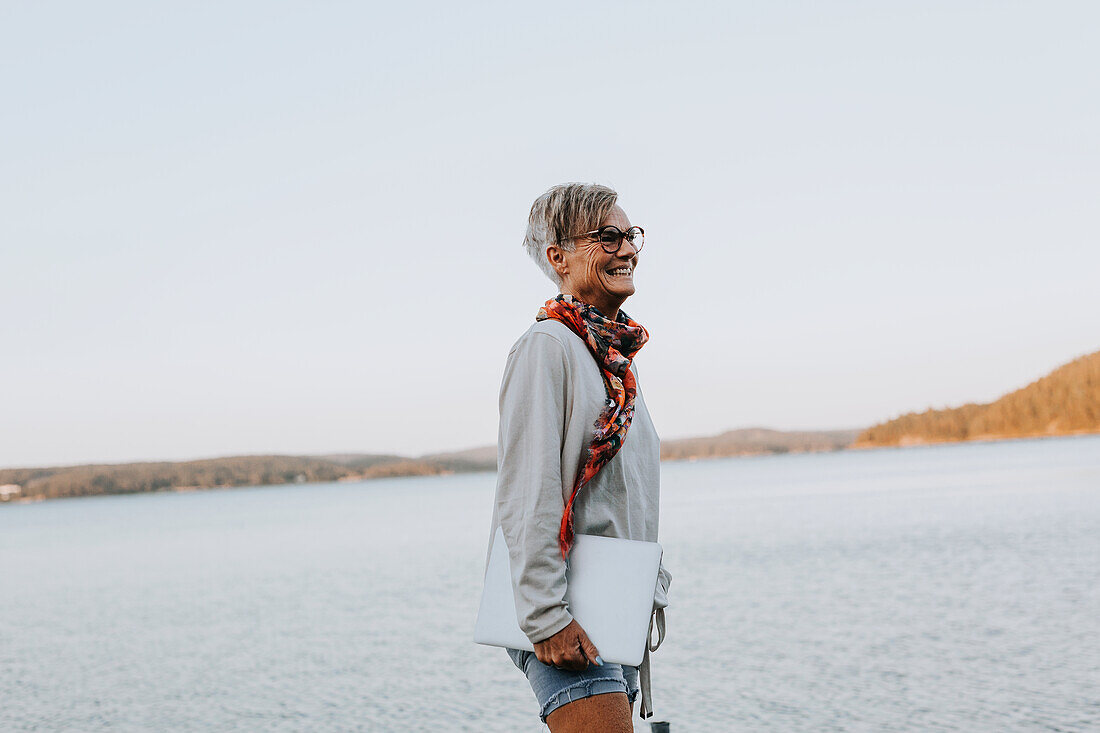 Frau am Meer mit Laptop