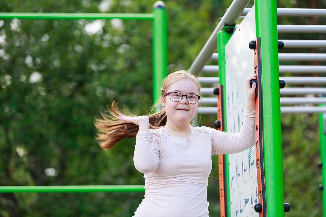 Lächelndes Mädchen auf dem Spielplatz schaut in die Kamera