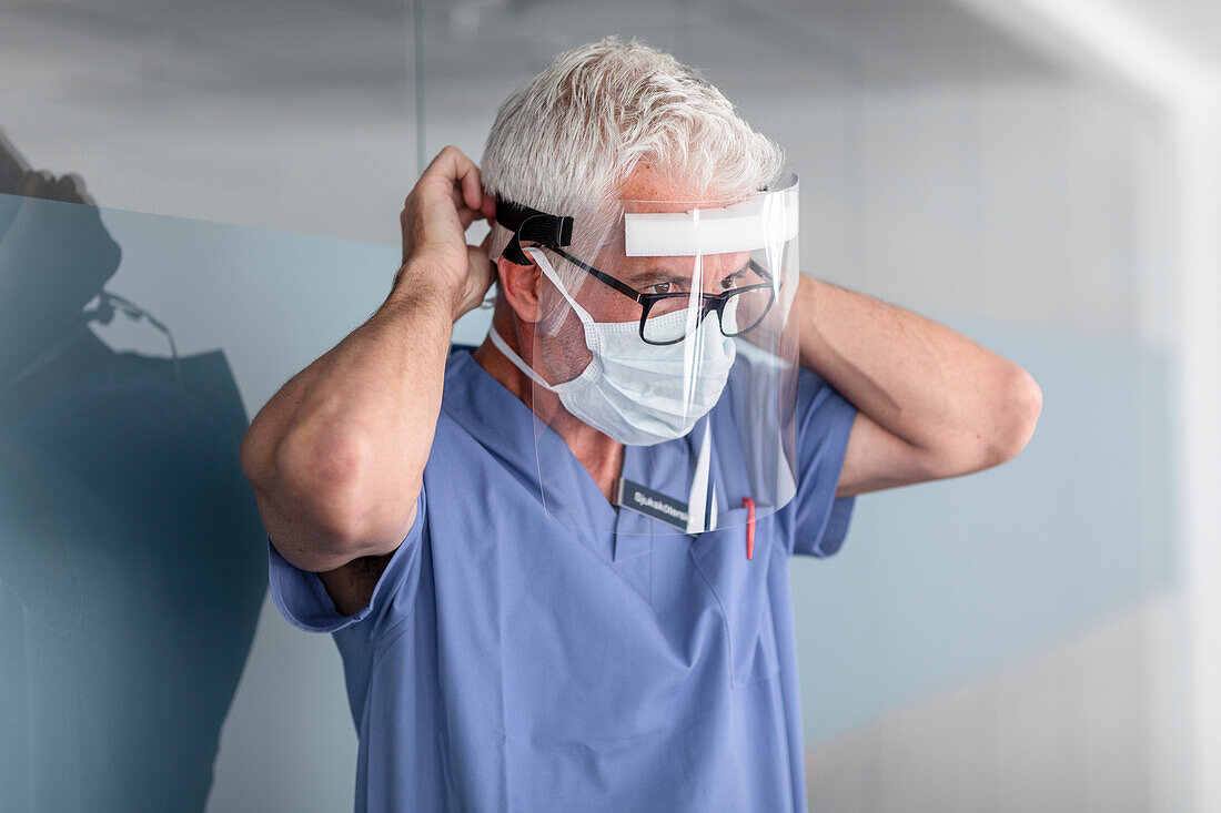 Doctor putting face shield on