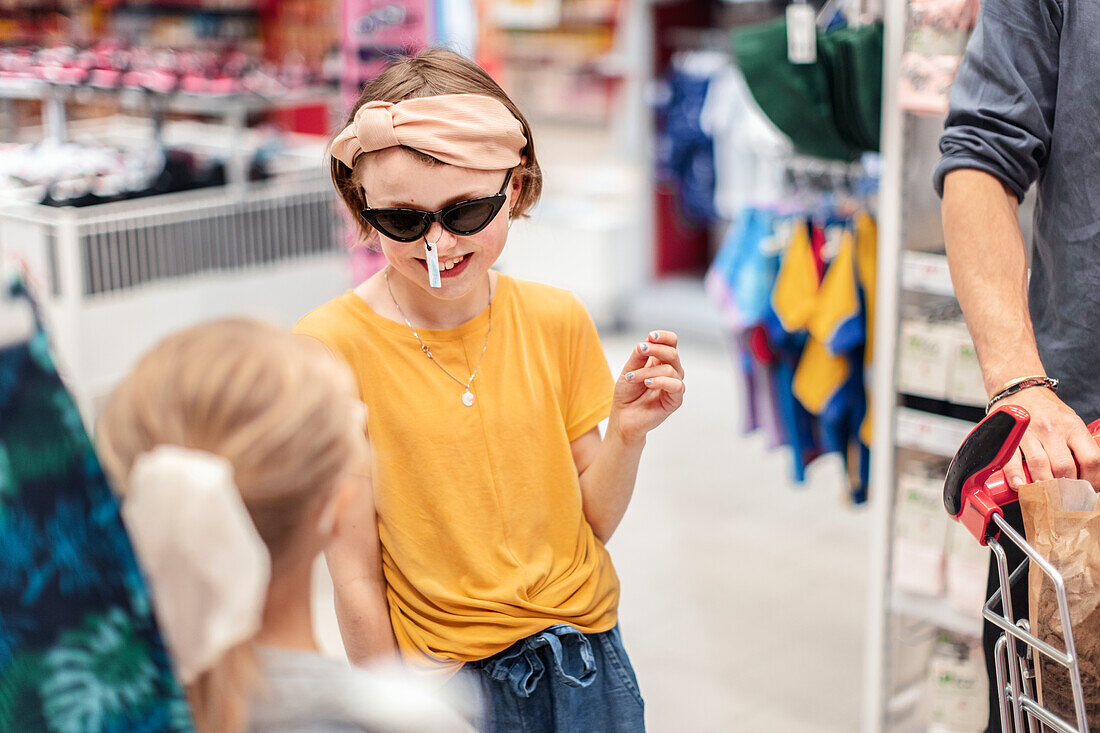 Smiling girl trying sunglasses in shop