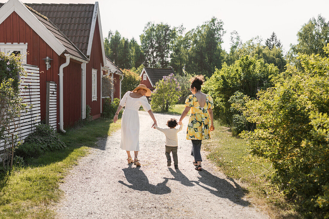 Kleinkind geht mit Mutter und Großmutter spazieren