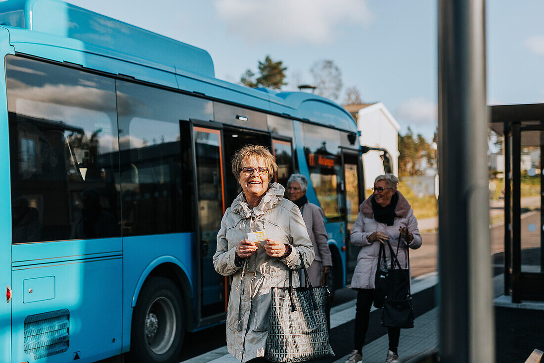 Lächelnde Frau am Busbahnhof