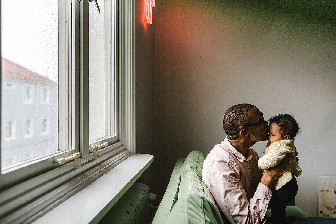 Father kissing baby daughter