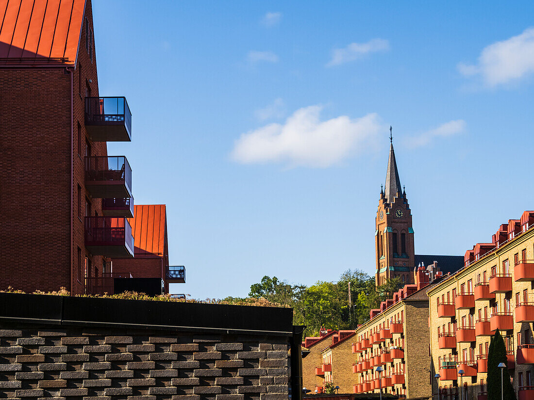 Low angle view of church tower, blocks of flats in foreground