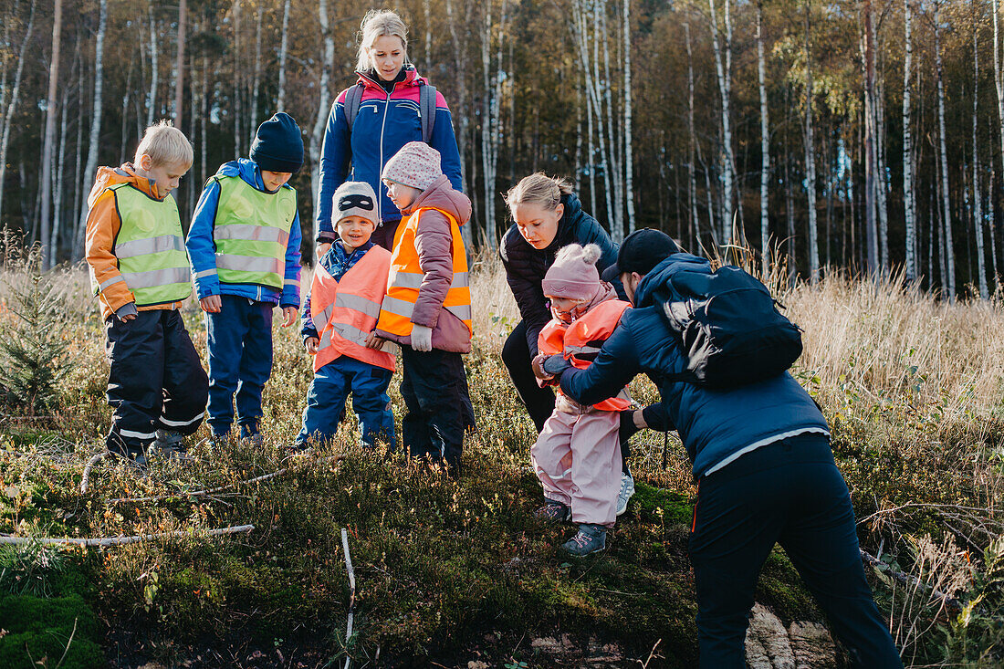 Kindergärtnerin geht mit Kindern spazieren