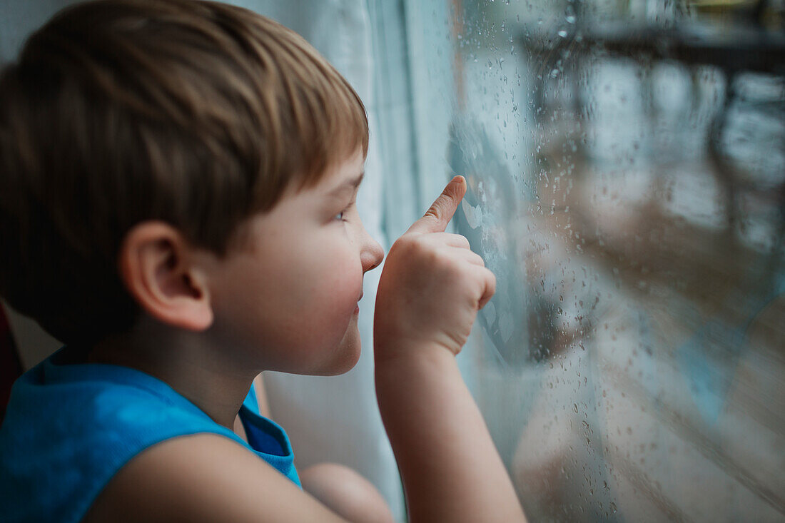 Boy drawing on window