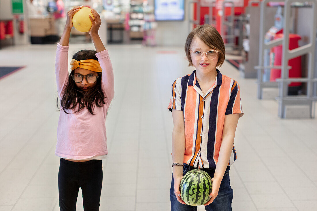 Mädchen im Supermarkt mit Früchten in der Hand