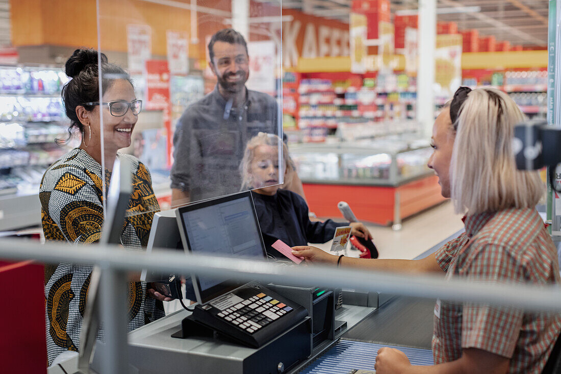 Family at till in supermarket