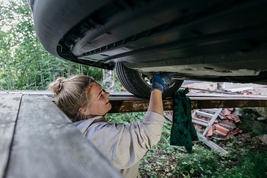 Frau repariert Auto