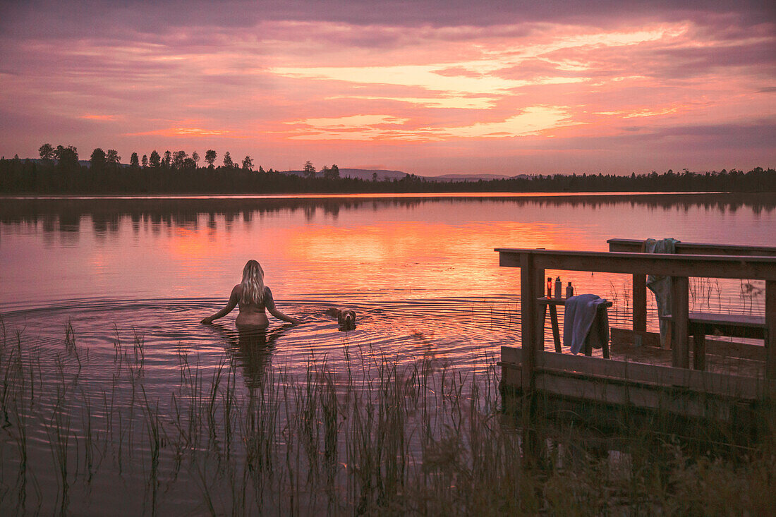 Woman in lake at sunset