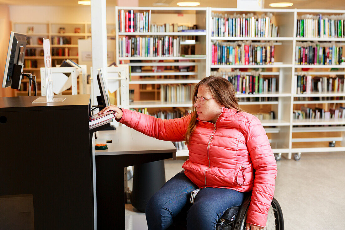 Woman on wheelchair in library