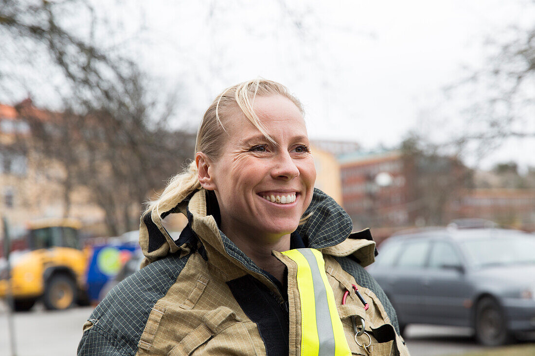 Smiling female firefighter looking away