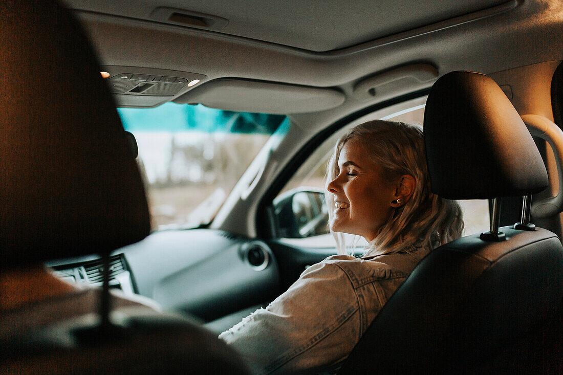 Lächelnde Frau im Auto sitzend