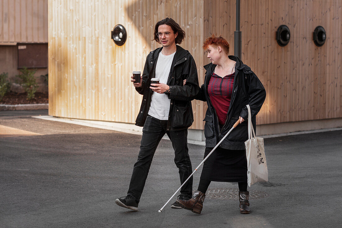 Sehbehinderte Frau geht mit männlichem Freund spazieren