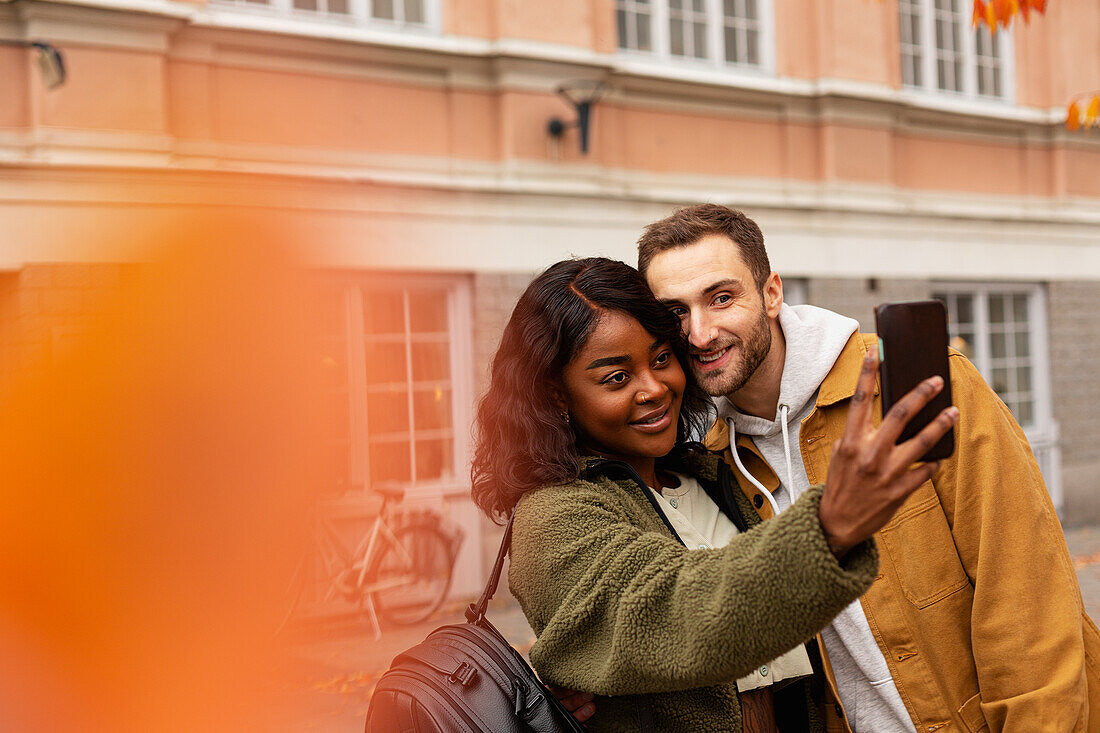 Young couple taking selfie on street