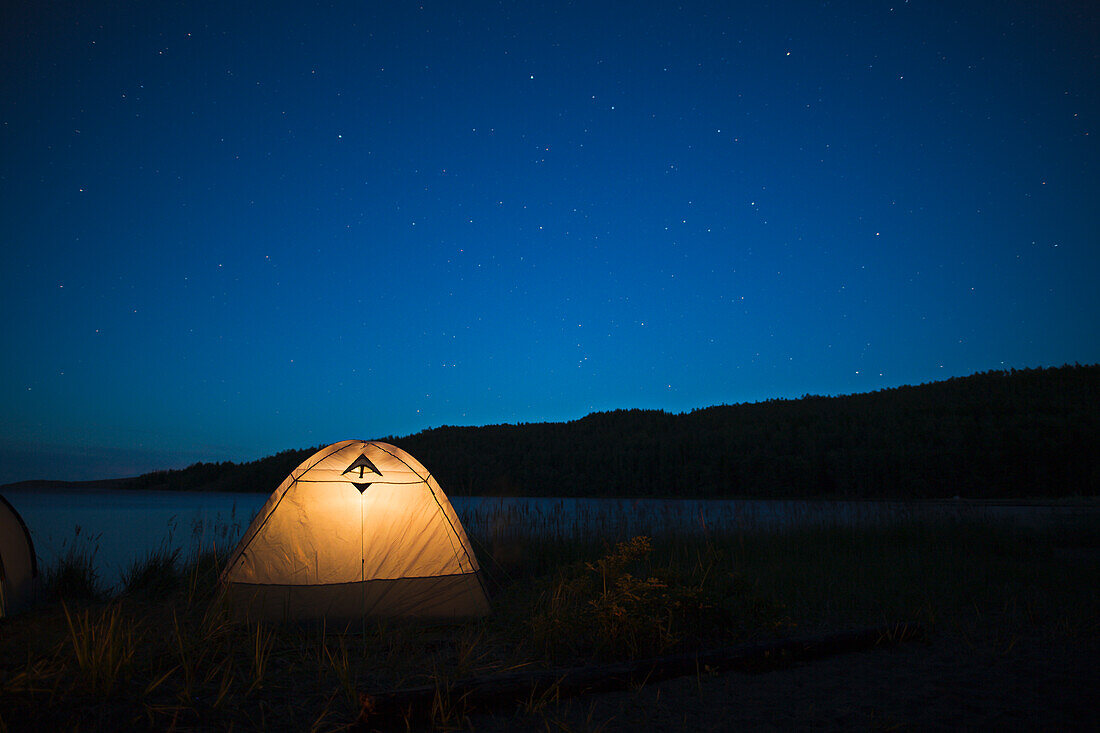 Illuminated tent at lake