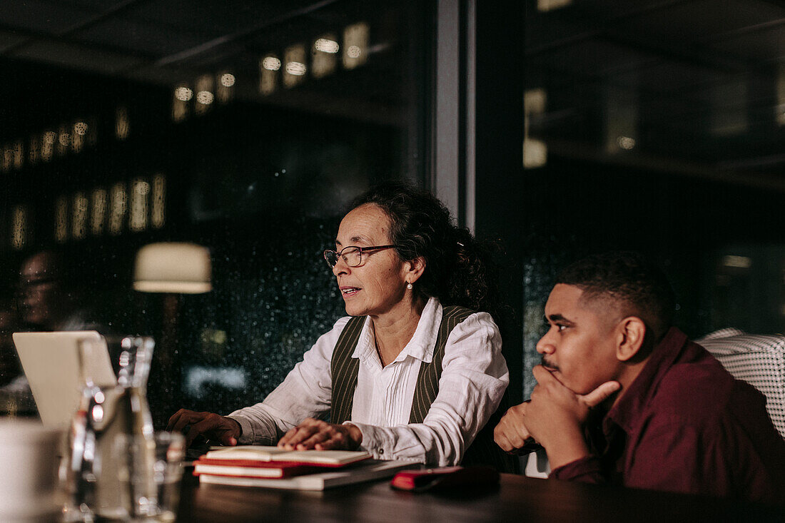 Man and woman in office at night