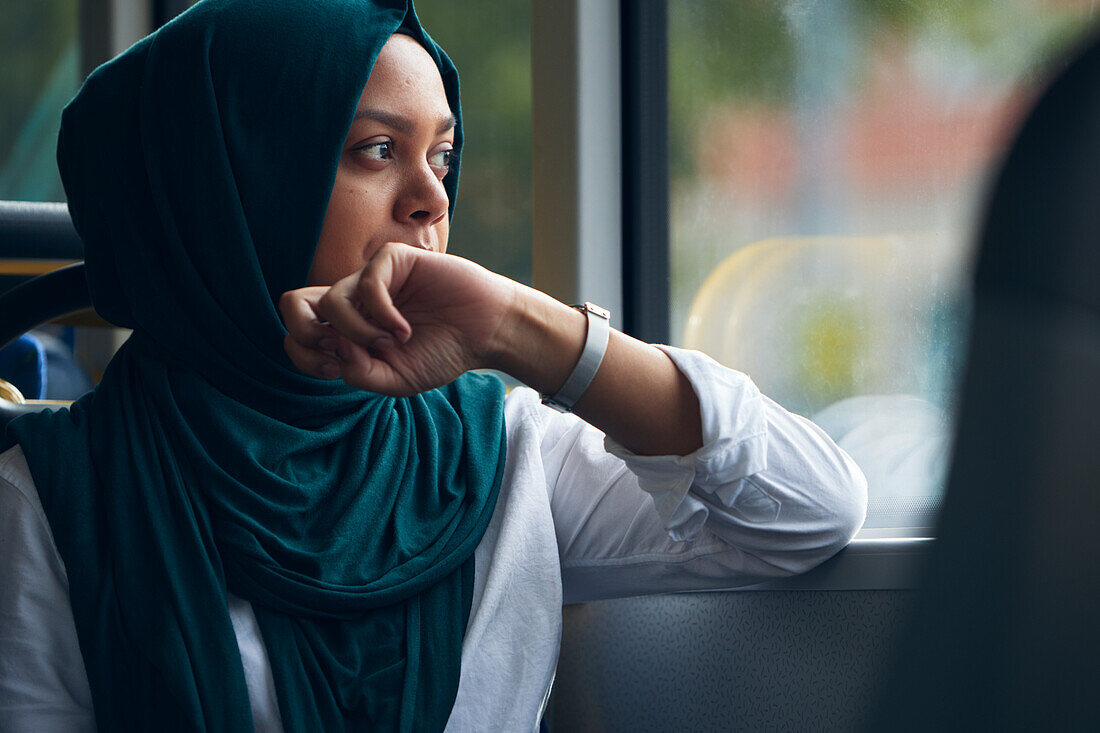Young woman in bus looking through window