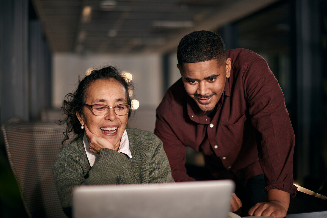 Coworkers using laptop