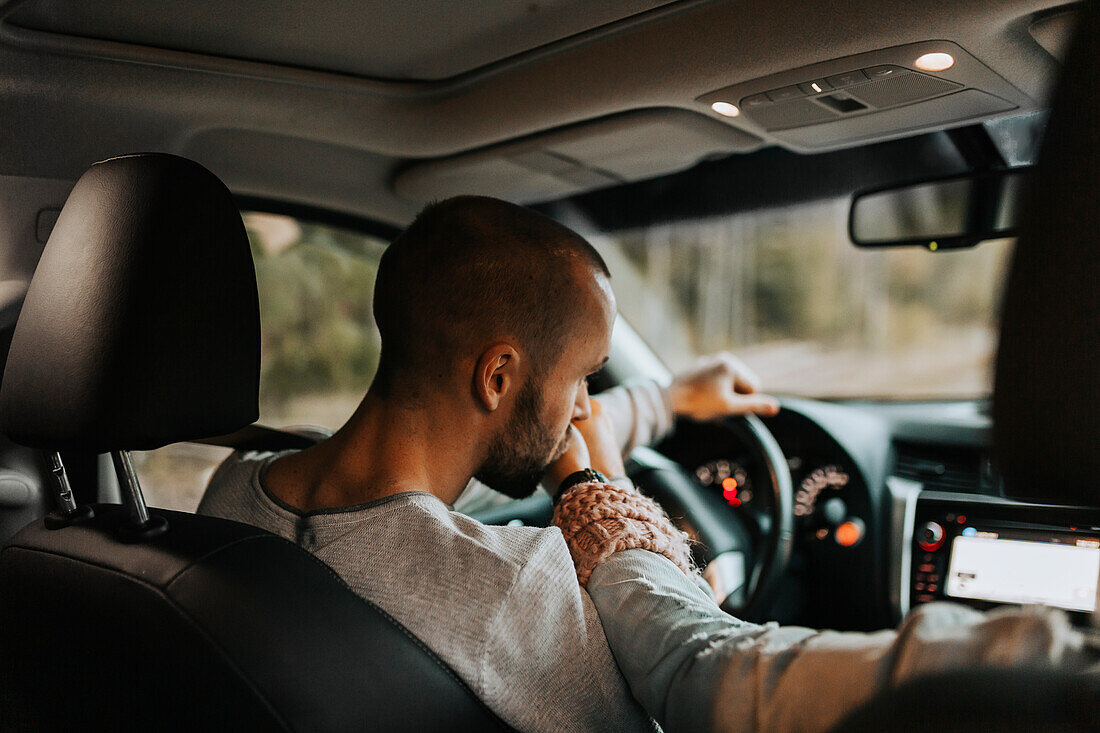 Driver in car kissing womans hand