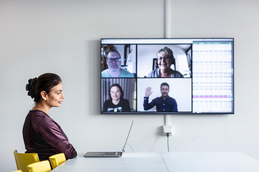 Woman in boardroom having video conference