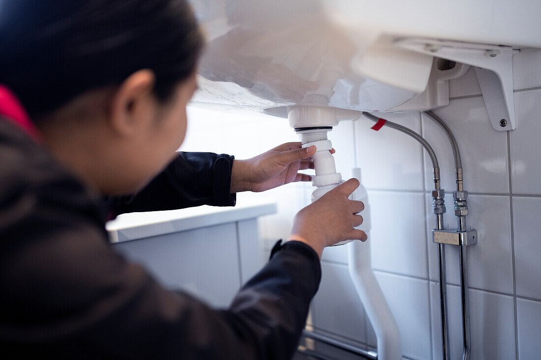 Woman fixing bathroom sink