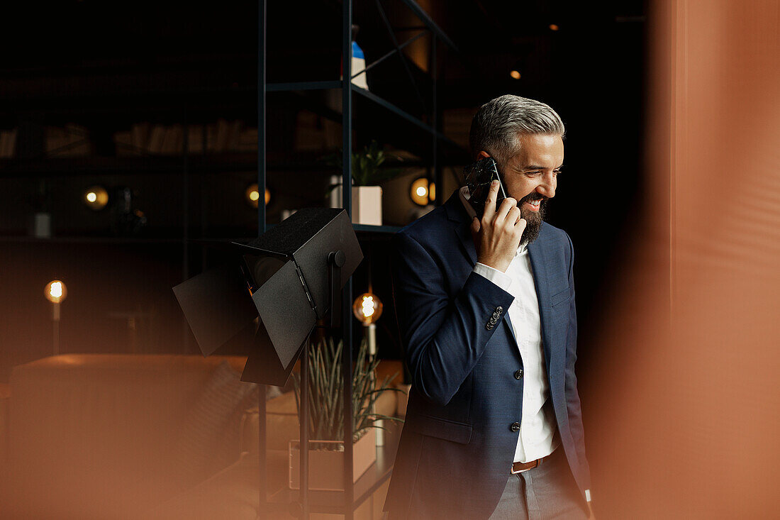 Businessman talking via cell phone in cafe