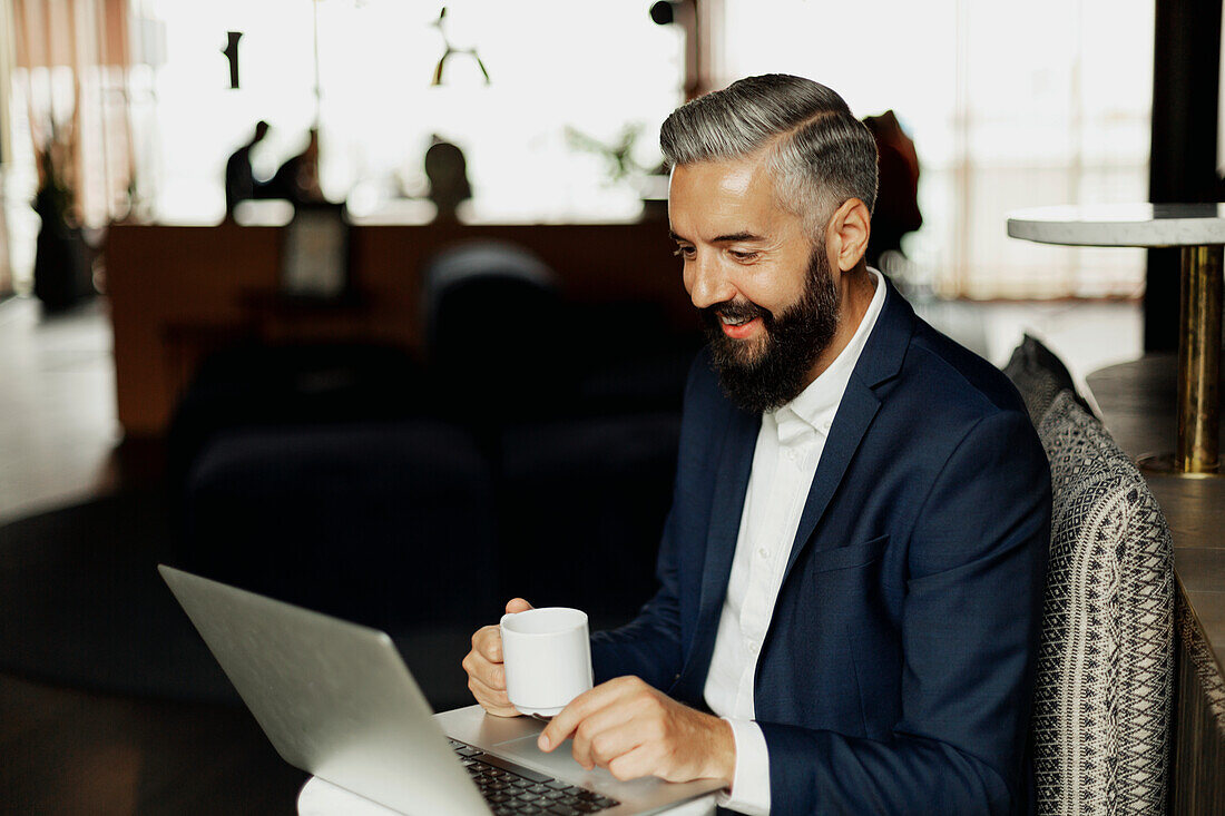 Businessman using laptop in cafe