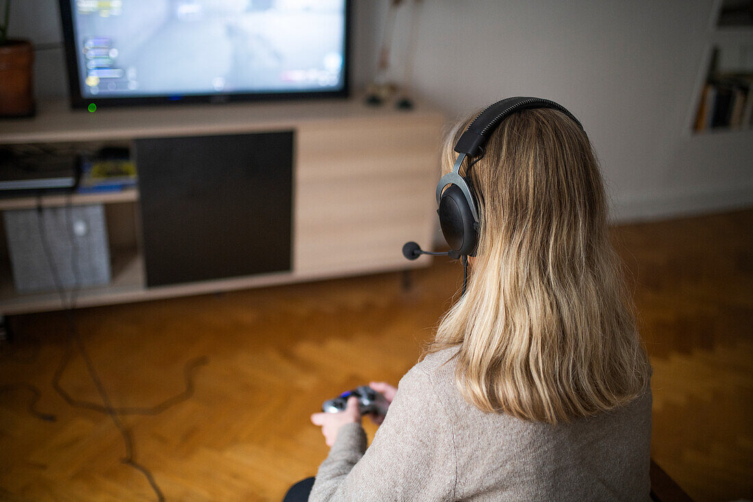 Frau mit Kopfhörer spielt ein Videospiel