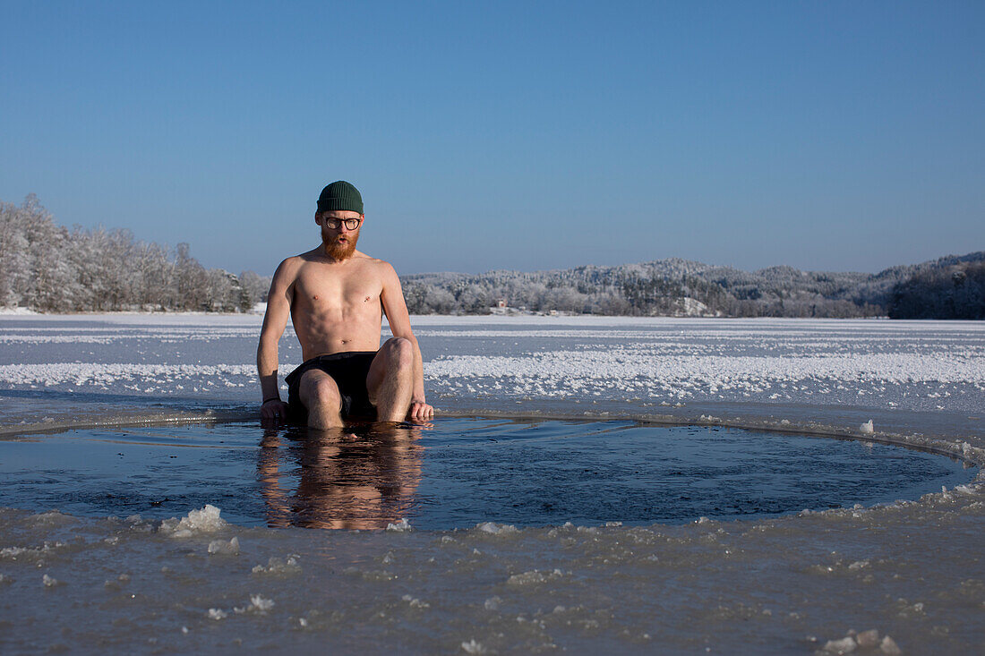 Mann schwimmt in gefrorenem See