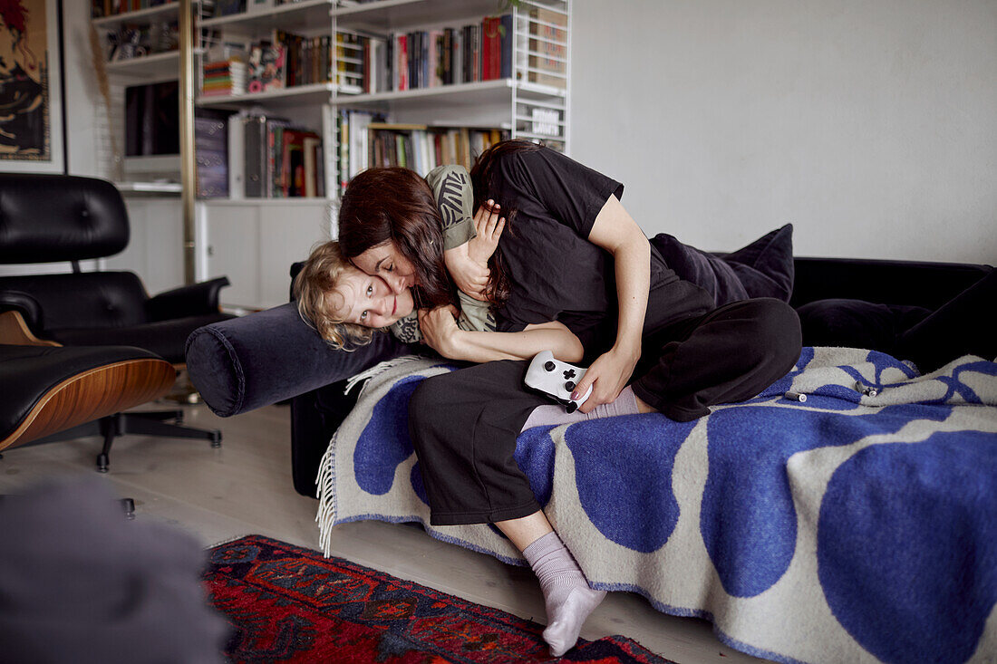 Mother and son hugging on sofa