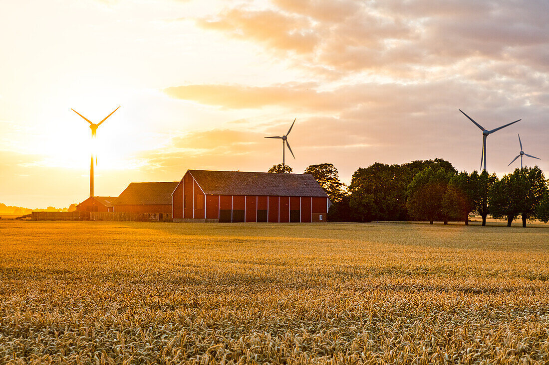 Bauernhof und Windkraftanlagen in ländlicher Umgebung