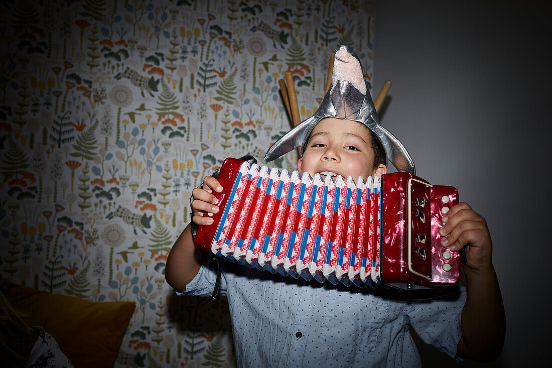 Smiling boy playing accordion