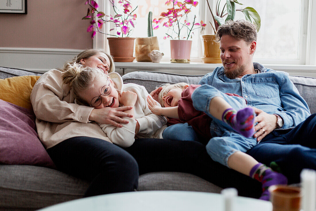 Eltern mit Kindern auf dem Sofa sitzend