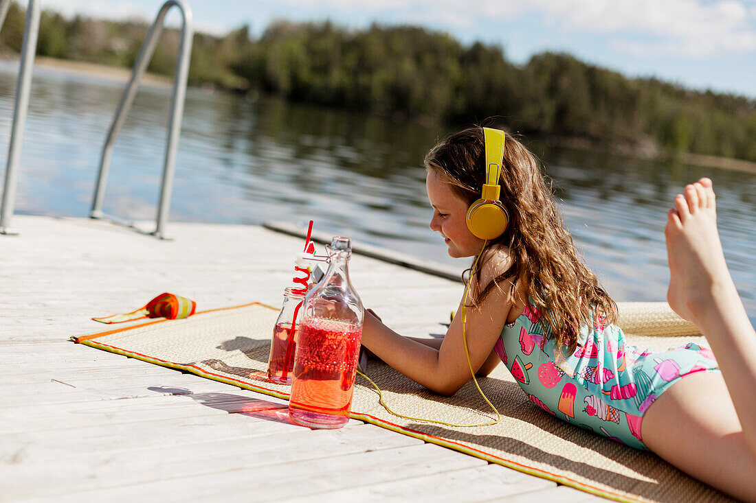 Girl using digital tablet on jetty