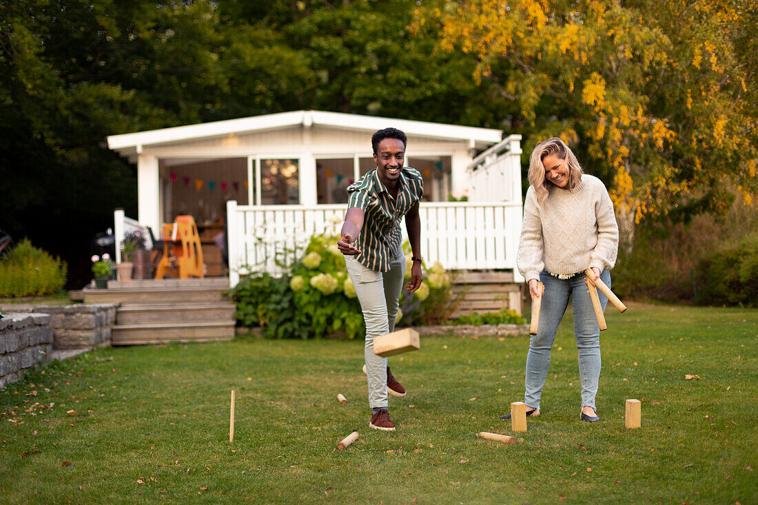 Man and woman playing molkky game in park