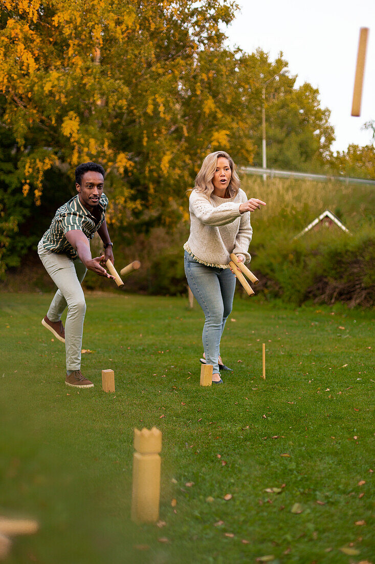 Mann und Frau spielen Molkereispiel im Park