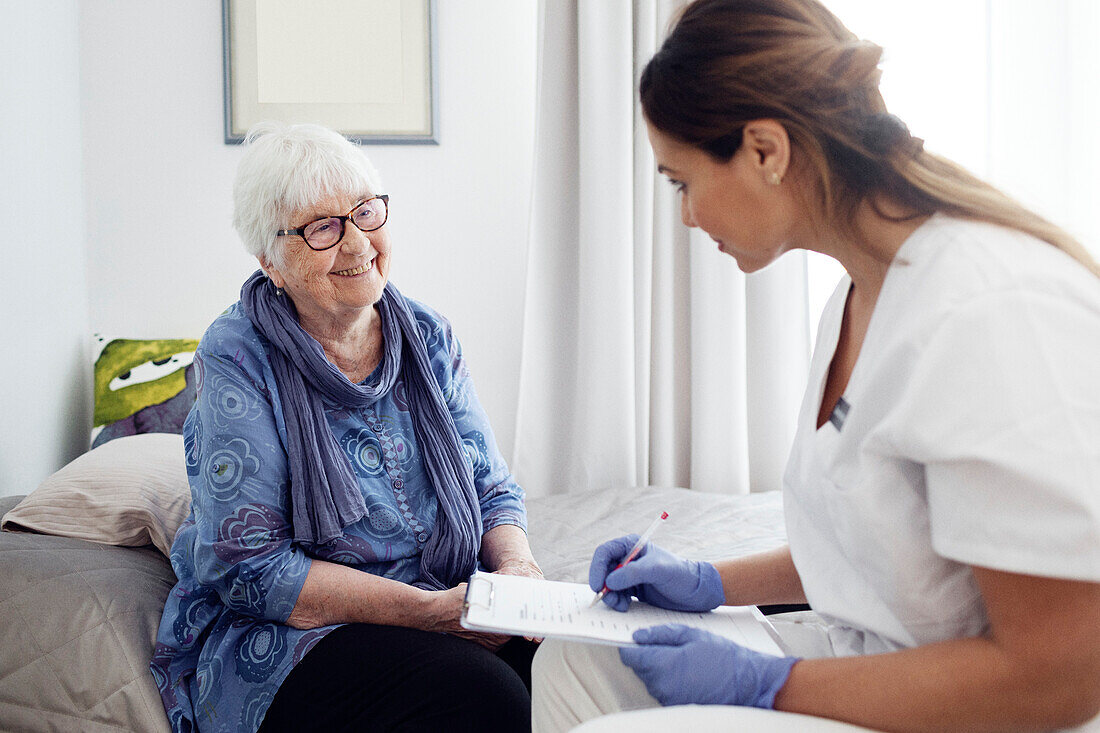 Krankenschwester mit älterer Frau zu Hause