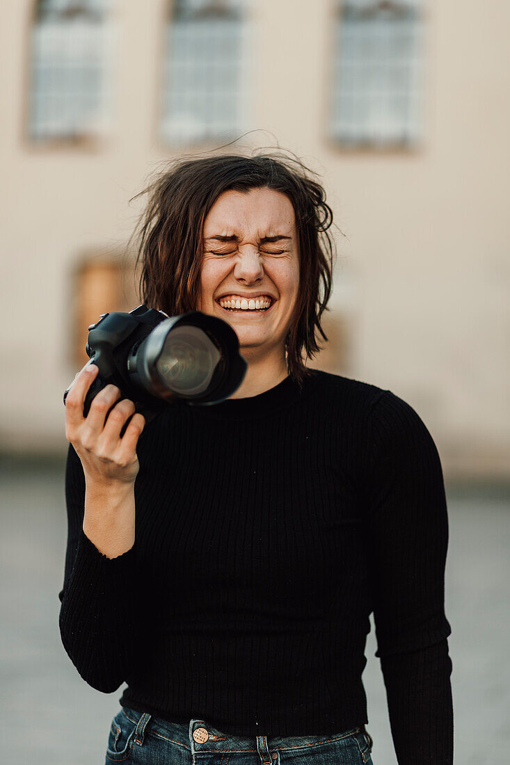 Happy woman holding camera