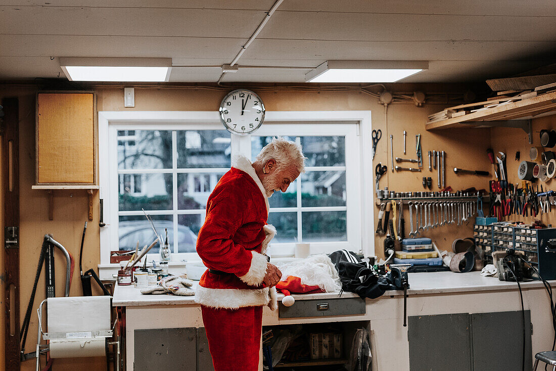 Senior man putting Santa costume on