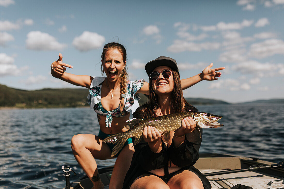 Glückliche Frauen mit Fisch in der Hand