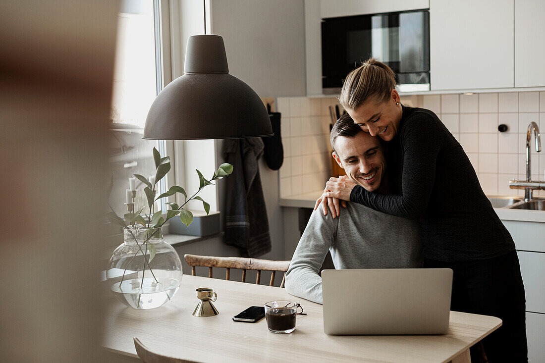 Couple hugging in kitchen