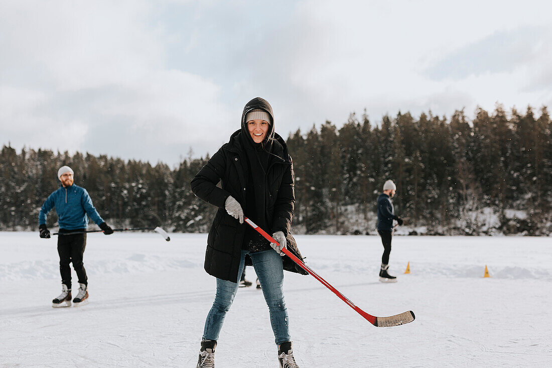 Woman playing hockey on frozen lake