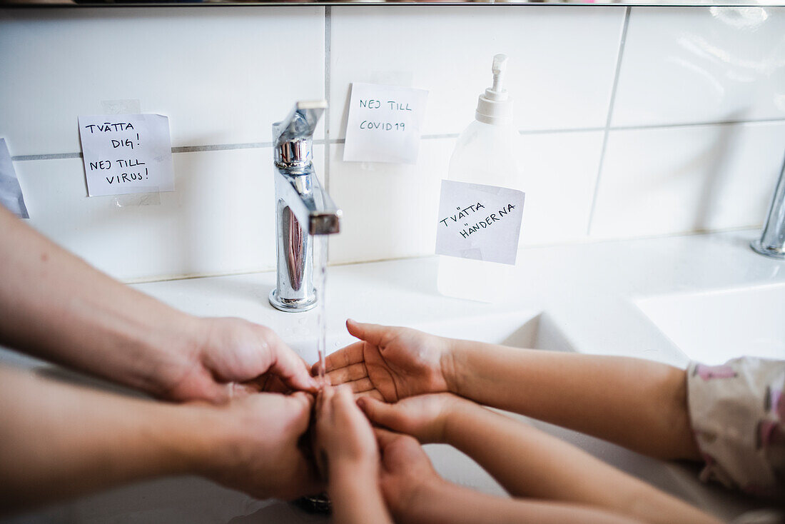 Father and child wash their hands