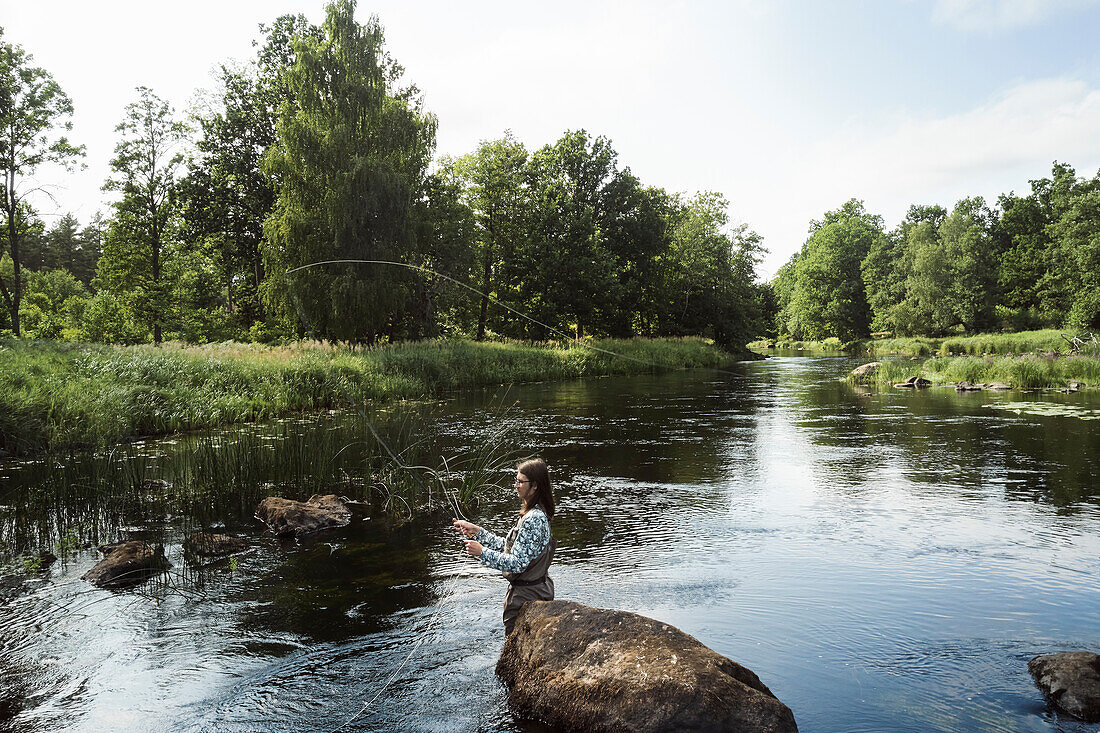 Frau beim Angeln im Fluss