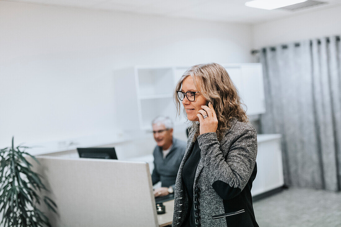 Woman using cell phone in office