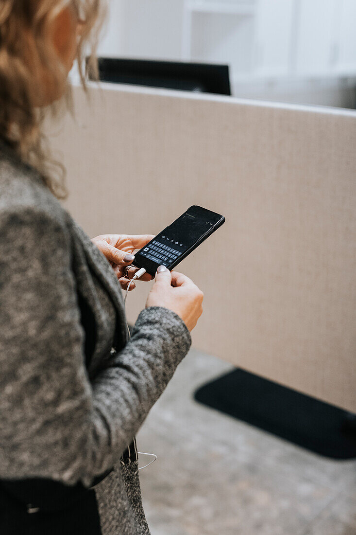 Mid section of woman using cell phone