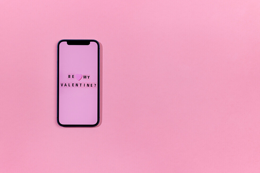 Smartphone mit Liebesbotschaft auf rosa Hintergrund