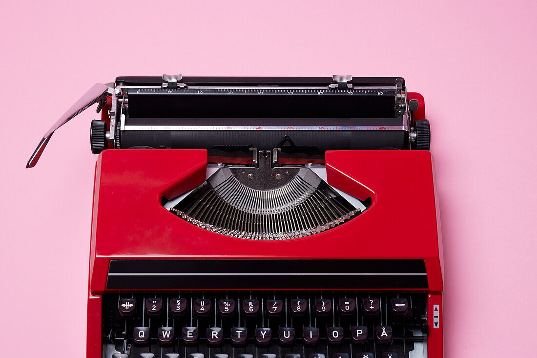 Red typewriter on pink background