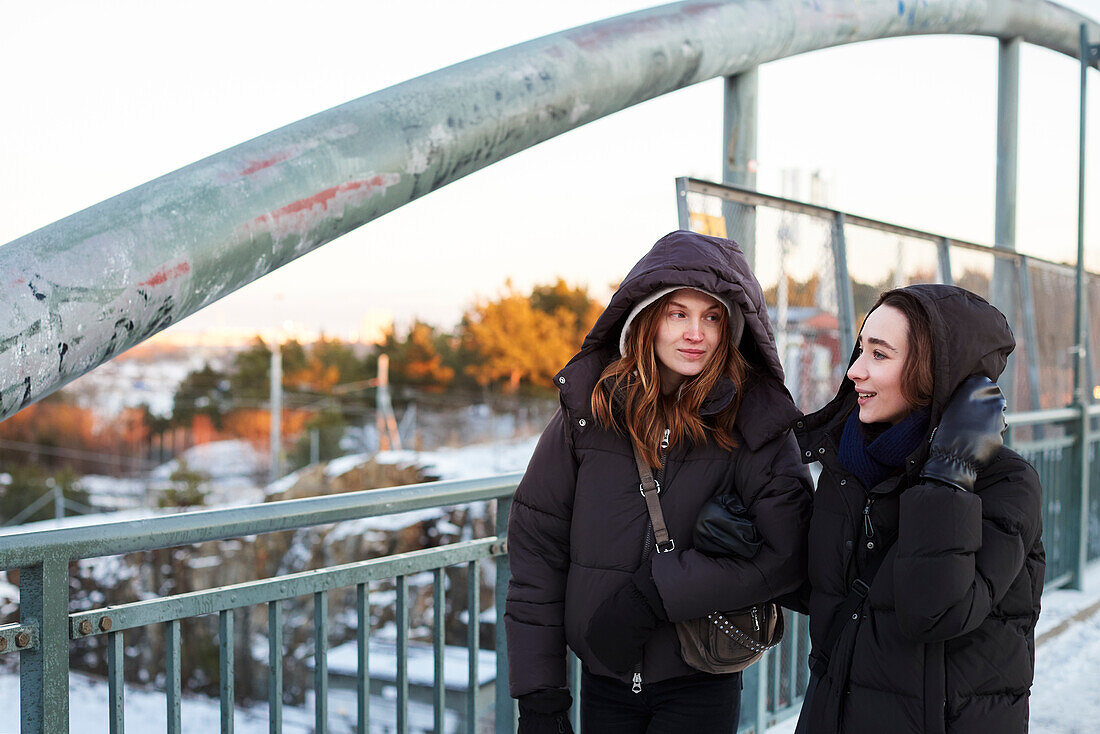 Young female couple walking on viaduct